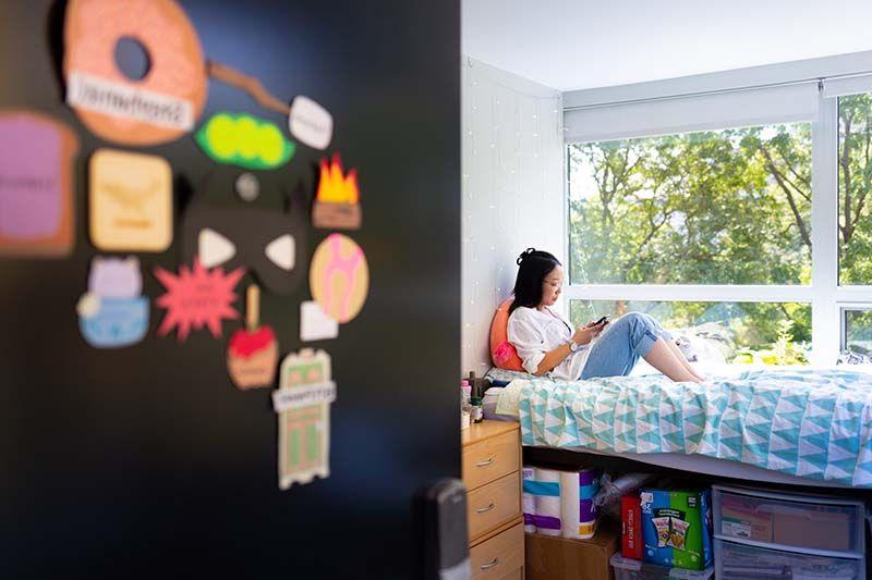 A student lounges in her room in Kacek Hall